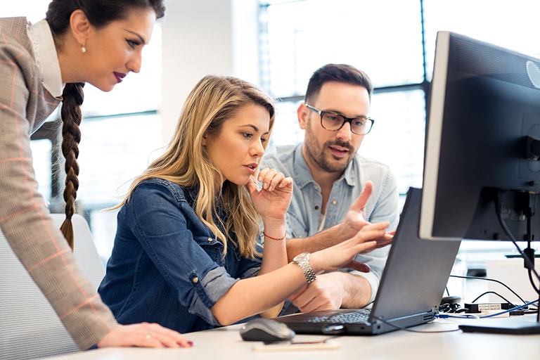 People attending a meeting in front of a laptop